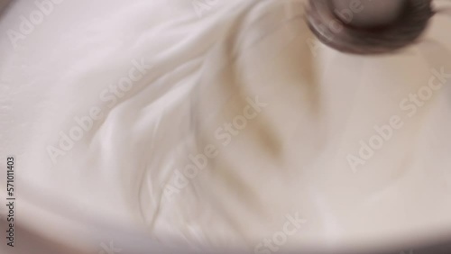 Kitchen mixer is beating the eggs white egg whites into a thick white foam. whisks whipped egg whites and sugar in the metal bowl. Whip the egg white: cook at home, make a cake, desserts, meringue