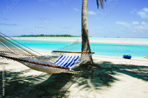 Hammock slung between palms in shade by waters edge of tropical holiday destination © Brian Scantlebury