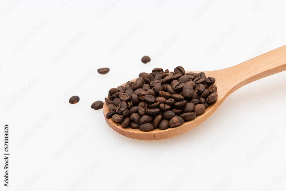 Granos de café en una cuchara de madera aislado sobre fondo blanco. Granos de café en una cuchara de madera aislado sobre fondo blanco.