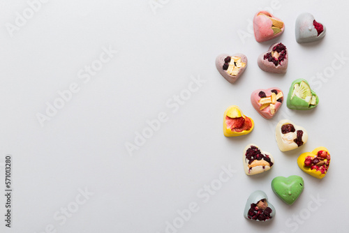 chocolate sweets in the form of a heart with fruits and nuts on a colored background. top view with space for text, holiday concept © sosiukin