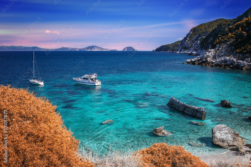 Naklejka premium Greckie krajobrazy z wyspy Skopelos. Relaks i wypoczynek na lazurowej zatoce z żaglówkami
