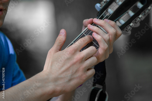close-up of rock musician playing acoustic guitar outdoors