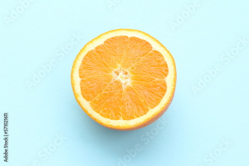 Half an orange isolated on light blue background