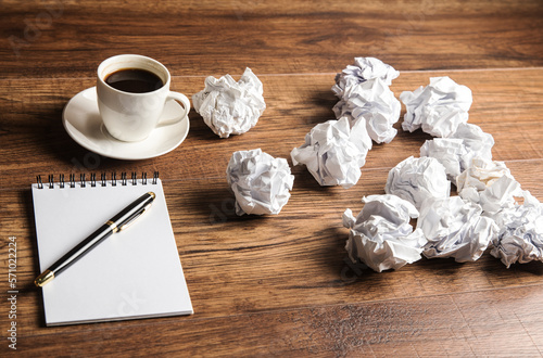 Notepad, cup of coffee and crumpled papers