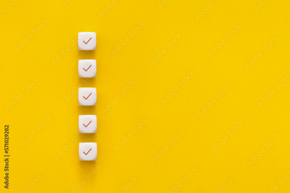Сubes with check mark on yellow background, Checklist concept with copy space. - obrazy, fototapety, plakaty 