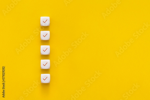 Obraz na płótnie Сubes with check mark on yellow background, Checklist concept with copy space. w salonie