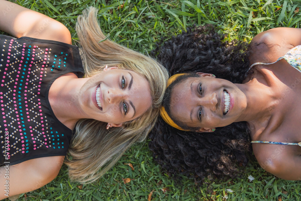 Smoking multiethnic females on grassy meadow Smoking multiethnic females on grassy meadow