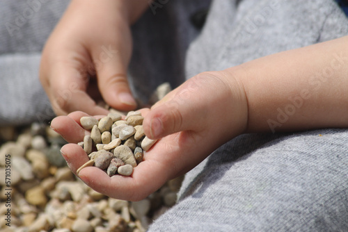 child with a handful of pebbles