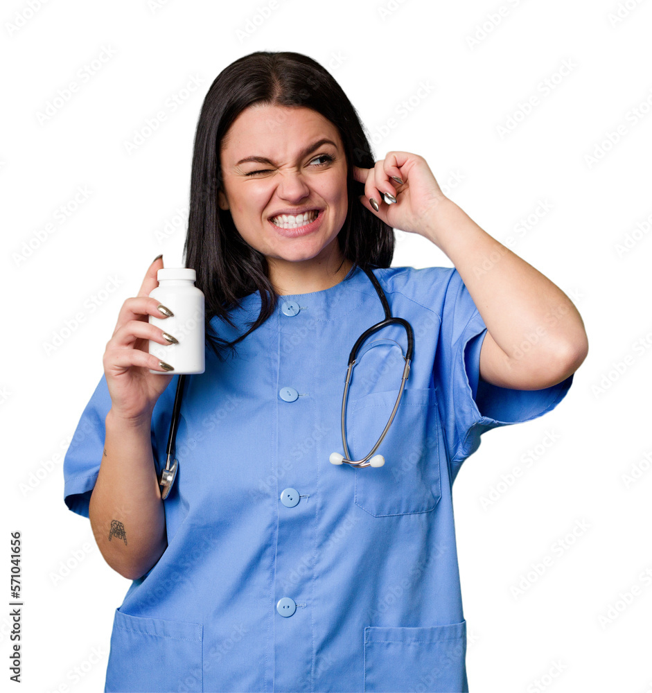 Young nurse woman holding pills isolated covering ears with hands. Young nurse woman holding pills isolated covering ears with hands.