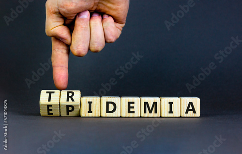 Covid-19 epidemic or tridemic symbol. Concept word Epidemic and Tridemic on wooden cubes. Doctor hand. Beautiful grey background. Medical Covid-19 epidemic or tridemic concept. Copy space