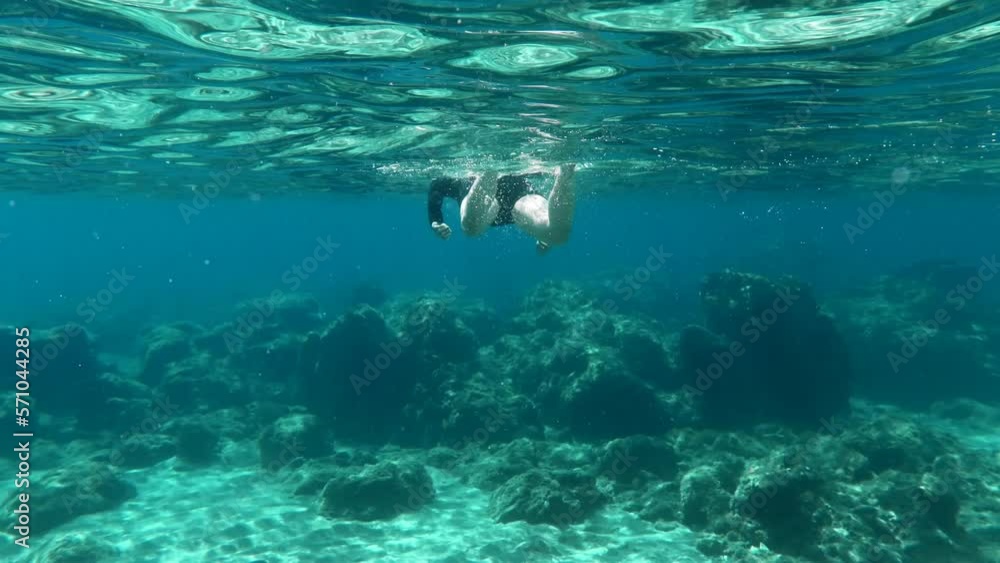 Snorkeling girl swimming in the ocea. Waves and swimmer, underwater video from snorkeling. Rocks and water. Snorkeling girl swimming in the ocea. Waves and swimmer, underwater video from snorkeling. Rocks and water.