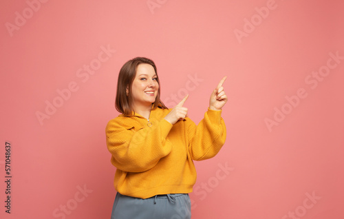 Woman having idea raising finger up isolated on pink color background