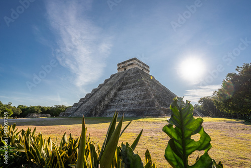 Photo of the pyramid in Chichen Itza taken through the plants.