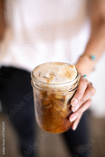 person holding a glass of iced coffee