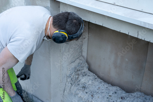Man Inspecting Demolished Concrete Wall for Window Installation