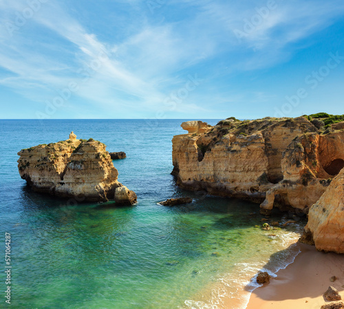 Summer evening Atlantic rocky coast view and sandy beach Praia de San Rafael with limestone cliffs, Albufeira, Algarve, Portugal).