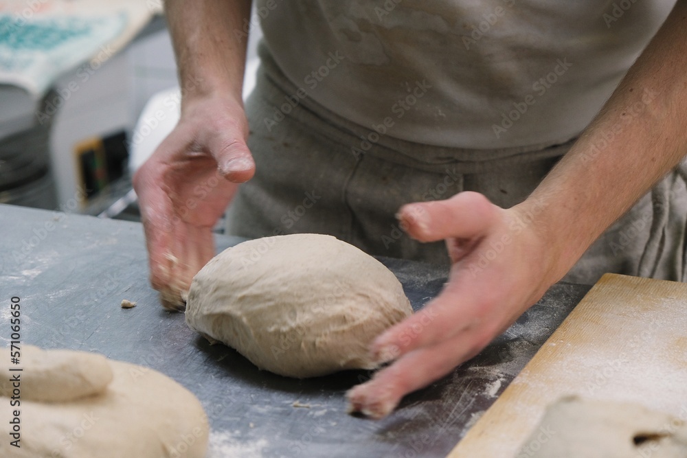baker at work. The baker shapes the bread. Hands on the close-up form bread