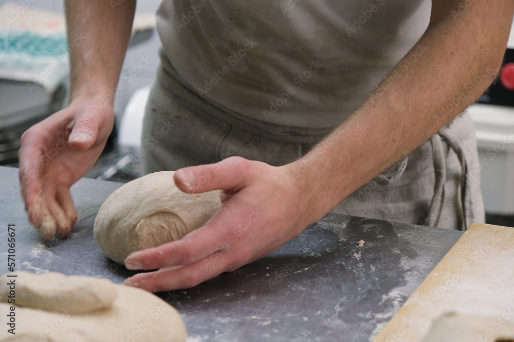 Fototapeta premium baker at work. The baker shapes the bread. Hands on the close-up form bread