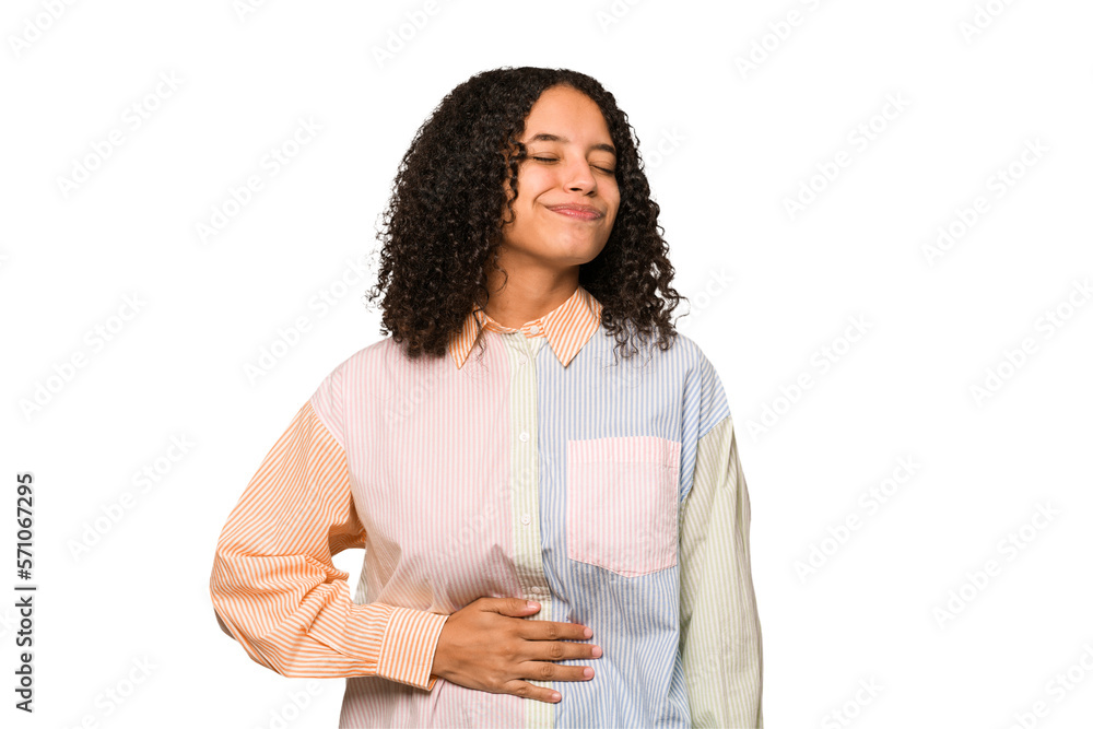 Fototapeta premium Young african american curly woman isolated touches tummy, smiles gently, eating and satisfaction concept.
