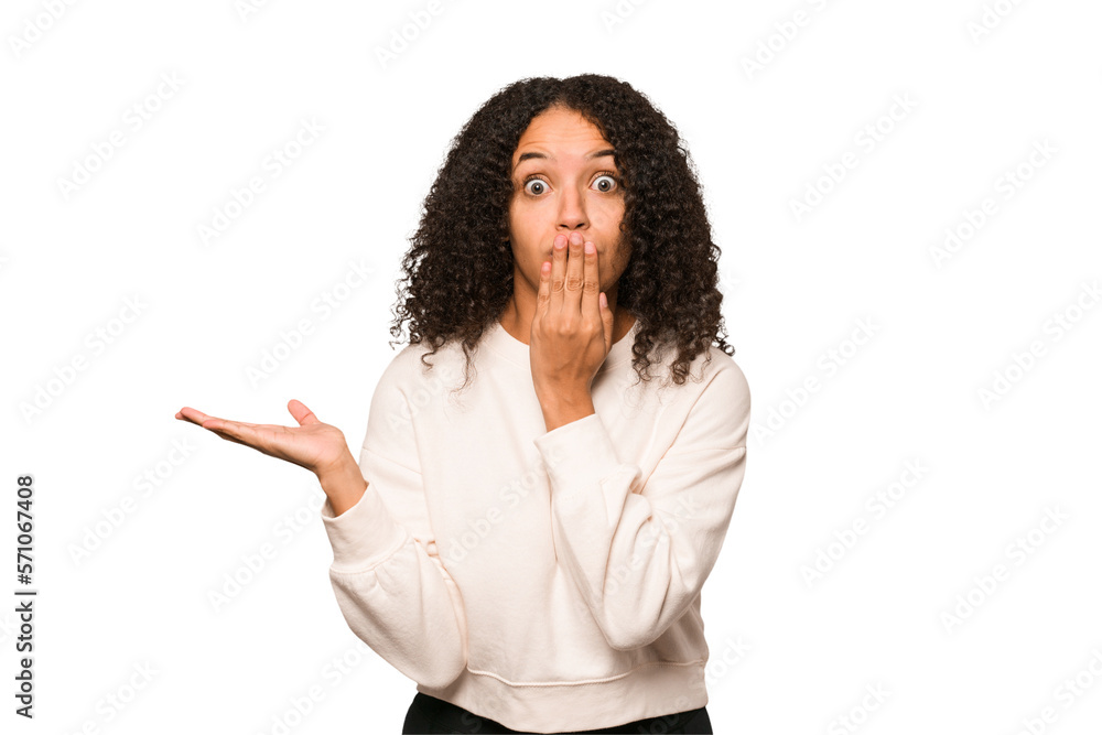 Young african american curly woman isolated impressed holding copy space on palm. Young african american curly woman isolated impressed holding copy space on palm.