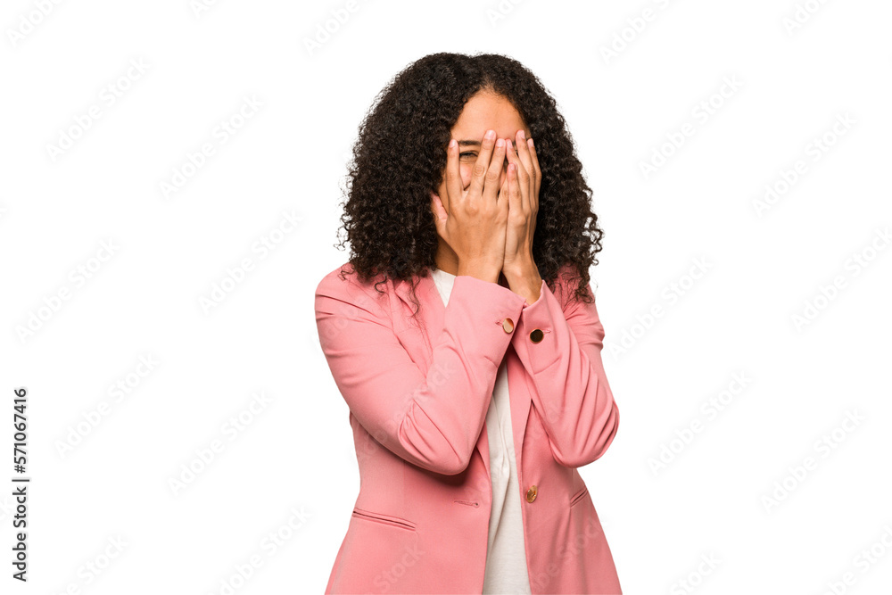 Young african american curly woman isolated blink at the camera through fingers, embarrassed covering face. Young african american curly woman isolated blink at the camera through fingers, embarrassed covering face.