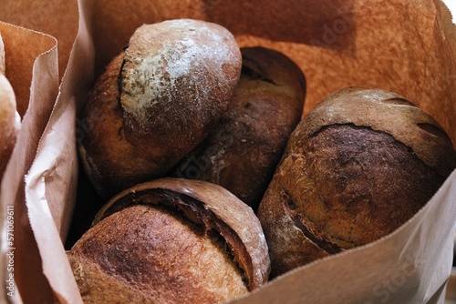 freshly baked bread in craft bags. Home baked whole grain bread. Crusty sourdough loaf of wheat bread with wholegrain flour. 