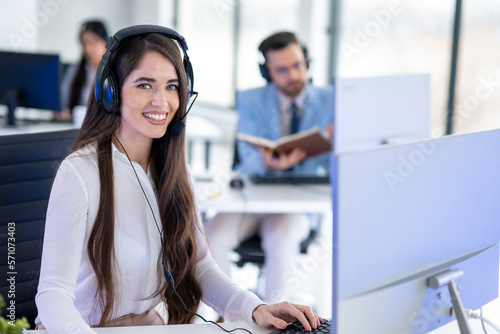 Portrait of beautiful young woman working as customer call center agent in call center office