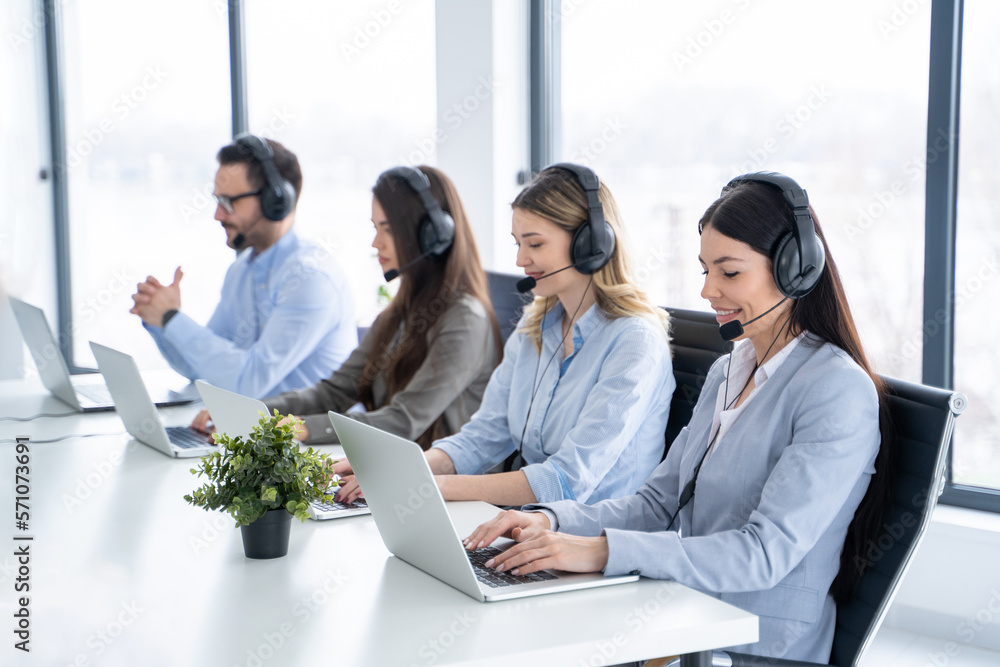 Group of friendly call center executives with headphones working in customer support service Group of friendly call center executives with headphones working in customer support service