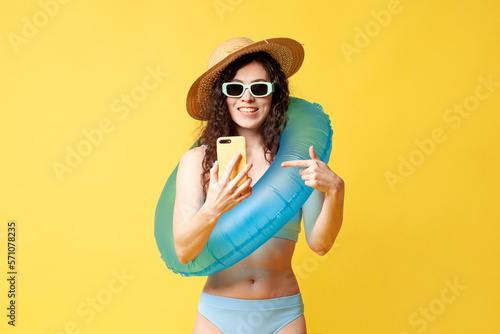 young girl in a blue swimsuit with a swimming inflatable ring uses smartphone and types message © Богдан Маліцький