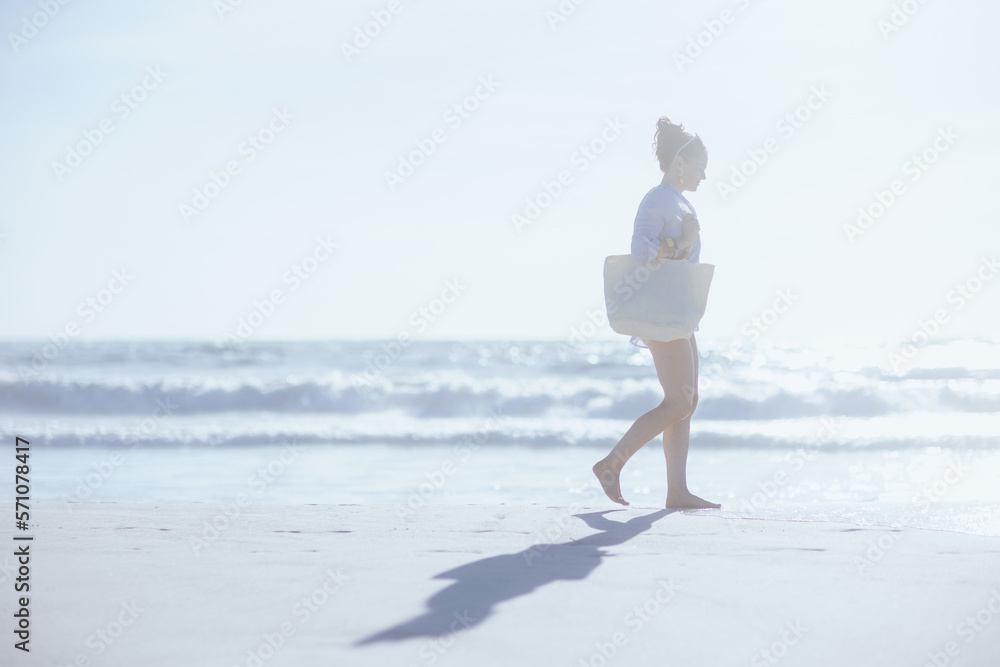 Full length portrait of happy modern woman walking at beach Full length portrait of happy modern woman walking at beach