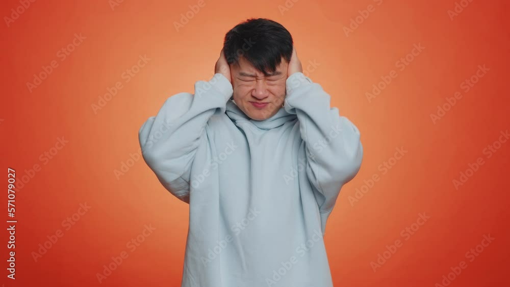 Asian tired man showing bla-bla-bla nonsense gesture with hands and rolling eyes, gossips, empty promises, blah concept. Liars. Handsome chinese guy isolated alone on orange studio wall background Asian tired man showing bla-bla-bla nonsense gesture with hands and rolling eyes, gossips, empty promises, blah concept. Liars. Handsome chinese guy isolated alone on orange studio wall background
