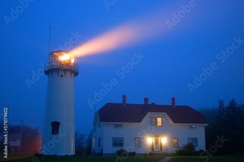 A beacon from the Chatham lighthouse on Cape Cod shines through the foggy and misty sky photo