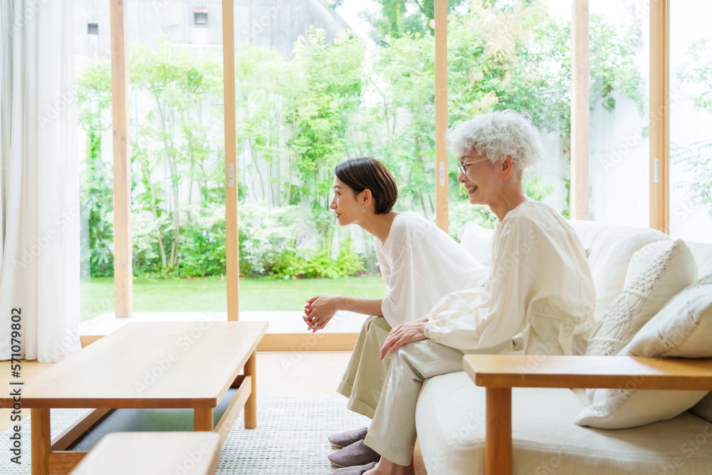 リビングで映画を観る母と娘 StockFoto Adobe Stock