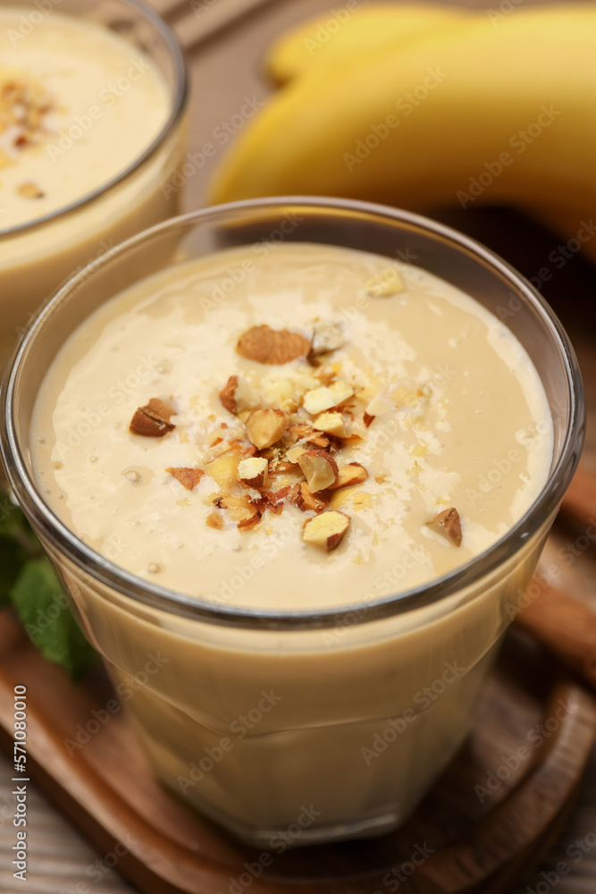 Tasty banana smoothie with almond and cinnamon on wooden table, closeup Tasty banana smoothie with almond and cinnamon on wooden table, closeup