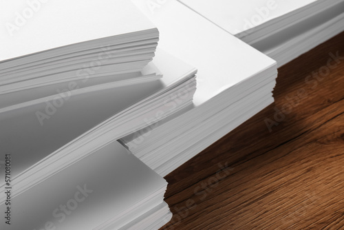 Stacks of white paper sheets on wooden table  closeup. Space for text