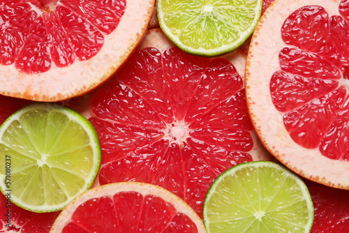 Slices of grapefruit and lime as background, top view
