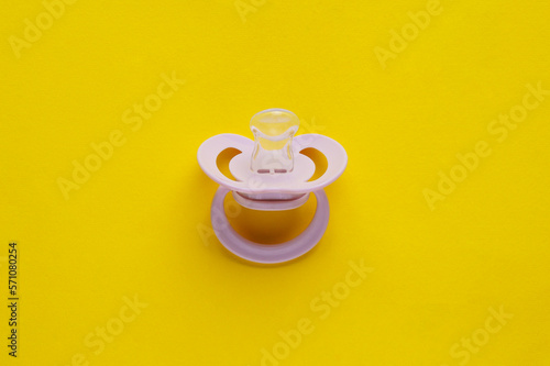 New baby pacifier on yellow background  top view