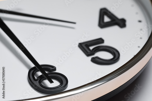 Stylish round clock on white background, closeup. Interior element photo