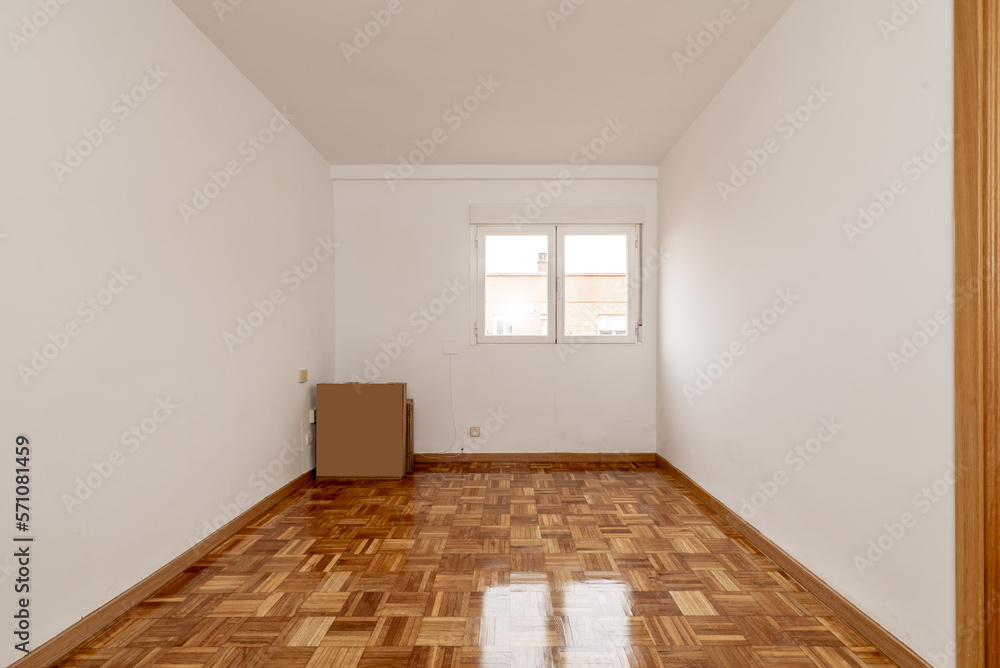 Empty one-story living room with parquet flooring of freshly stabbed and varnished oak slats and white aluminum windows Empty one-story living room with parquet flooring of freshly stabbed and varnished oak slats and white aluminum windows