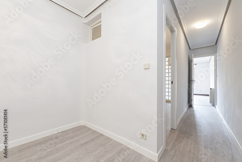 Distribution corridors of an empty house with light oak flooring  smooth white walls and white carpentry on doors and skirting boards