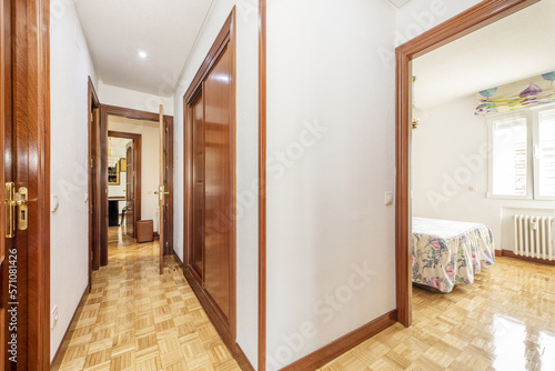 Distributor corridors of a house with French oak wooden floors in slats and sapele wooden doors with matching built-in wardrobes © Toyakisfoto.photos