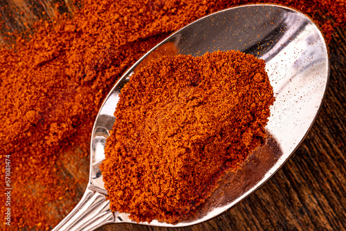 A metal spoon full of spicy paprika