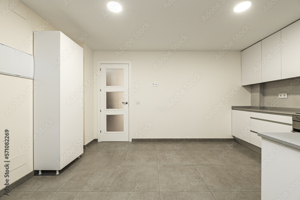 apartment kitchen with white cabinets, built-in stainless steel appliances, gray stone countertop, and gray tile kitchen walls and flooring apartment kitchen with white cabinets, built-in stainless steel appliances, gray stone countertop, and gray tile kitchen walls and flooring
