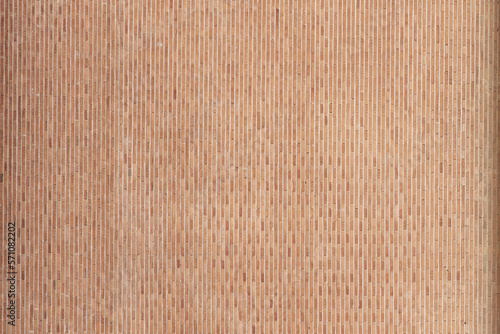 A surface of clay-colored bricks placed vertically. vector bricks background texture