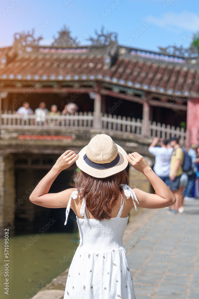 Woman traveler sightseeing at Japanese covered bridge or Cau temple in Hoi An ancient town, Vietnam. landmark and popular for tourist attractions. Vietnam and Southeast Asia travel concept