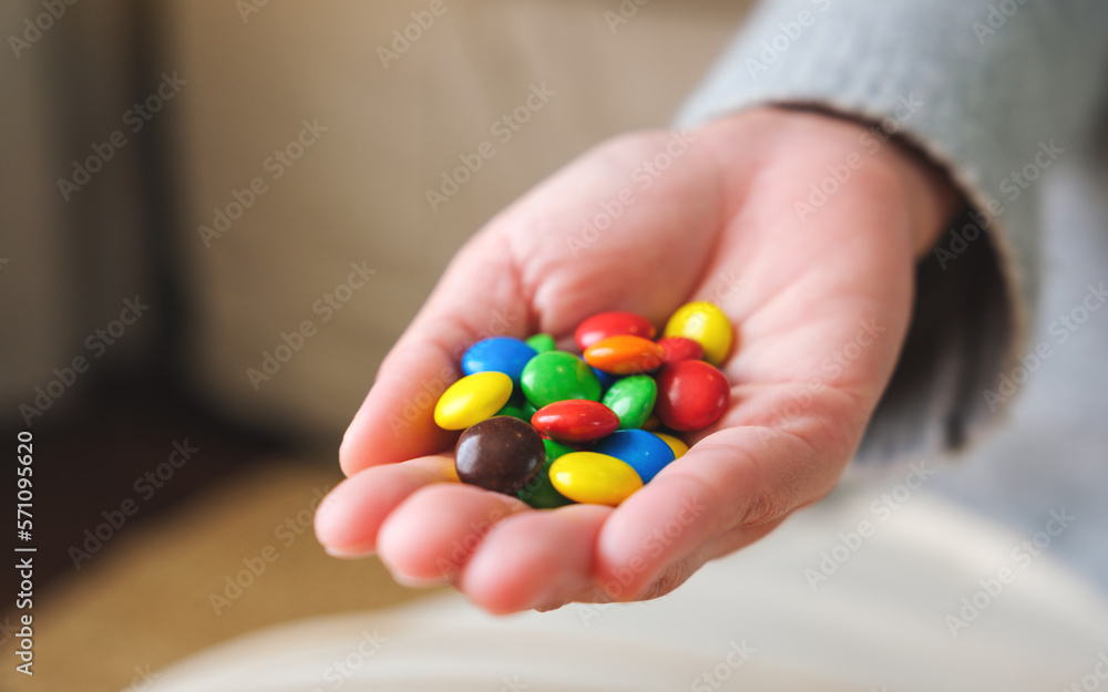 Closeup image of a hand holding colorful chocolate candy Closeup image of a hand holding colorful chocolate candy
