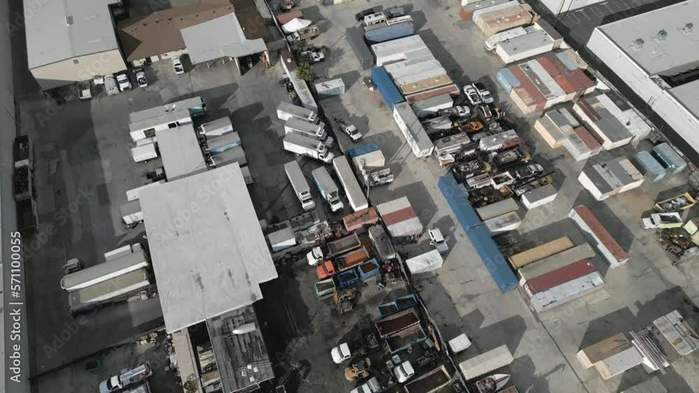 An industrial storage yard, filled with cargo shipping containers, box
