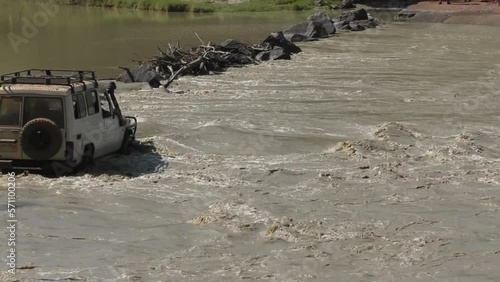 Jeep drives across Cahills Crossing in Australia as crocodiles wait just downstream. photo