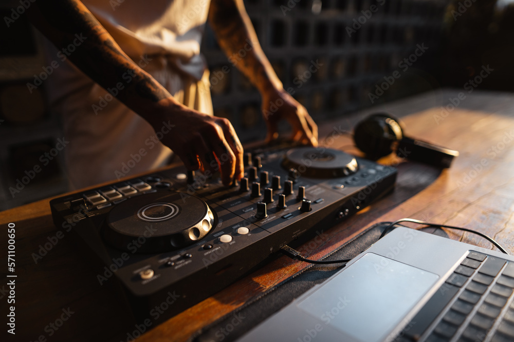 DJ playing music,Man using mixing desk at party out in the evening DJ playing music,Man using mixing desk at party out in the evening