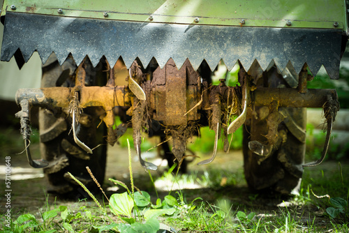 Rototiller of a walk-behind tractor close-up. Agricultural machinery for processing and care of the soil. Small tractor for plowing the garden soil photo